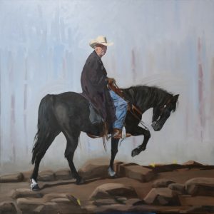 Oil painting of a cowboy in hat riding a black horse over rocky terrain—‘Honcho’ by artist Randy Wheeler